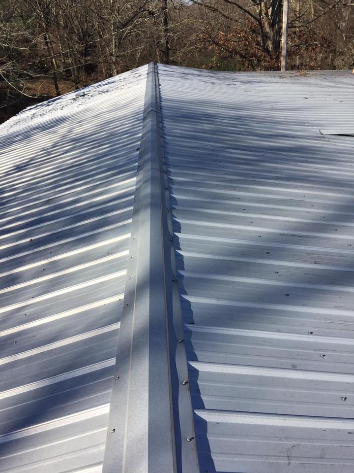 Metal roof panels and ridge cap on a metal roofing job in Benton AR