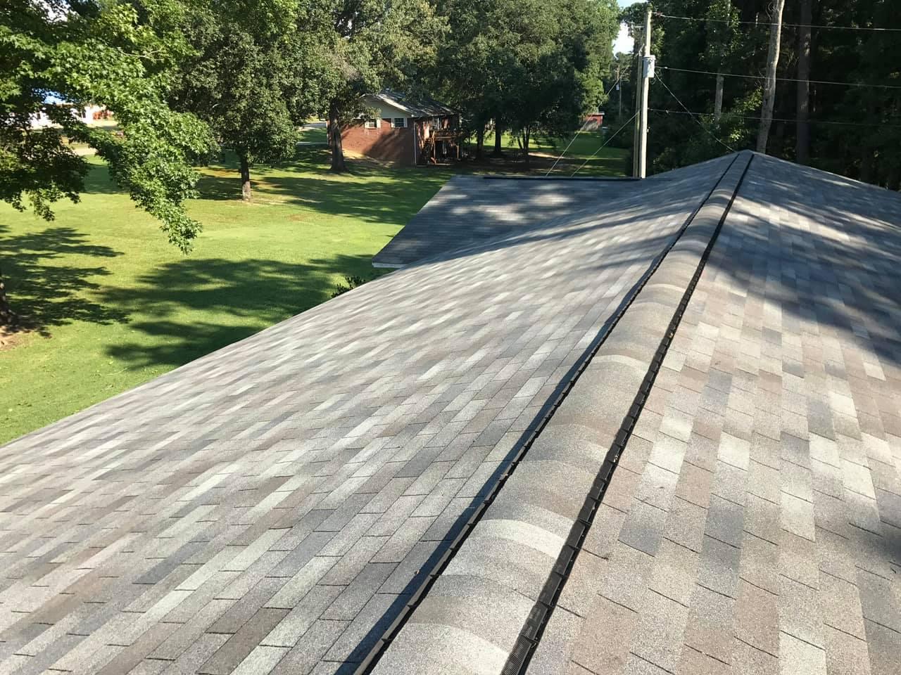 Ridge cap shingles on a new roof after storm damage, insurance roofing in central Arkansas