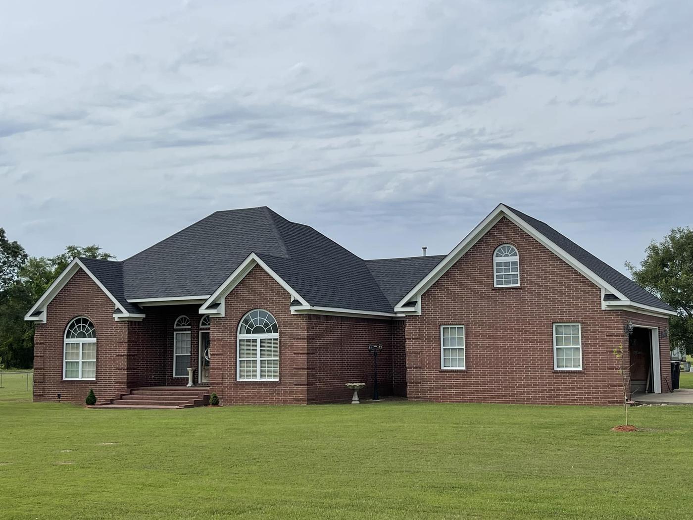 Brick home in Benton AR with a new dark shingle roof from a full roof replacement